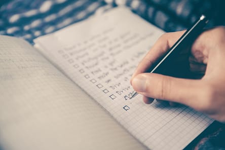 Photo by Glenn Carstens-Peters person writing bucket list on book